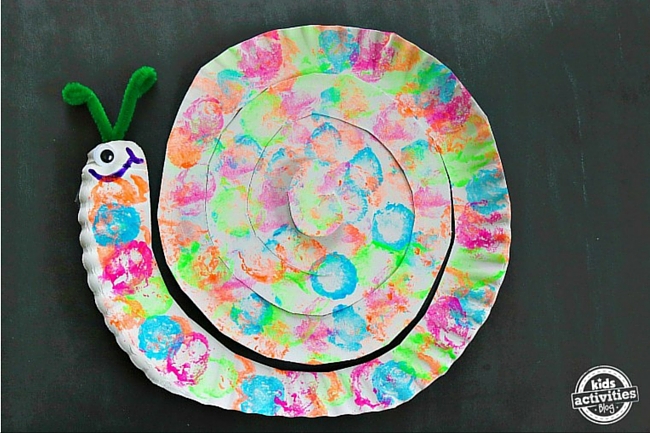 5 minute paper plate snail craft for kids on black background