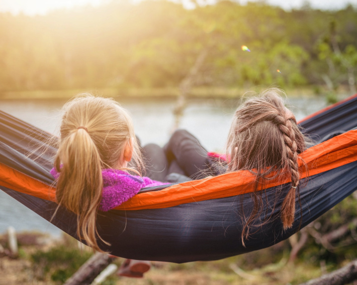 Activities for Elementary Age Kids - Grade School Age - fun things from Kids Activities Blog - two 10 year old girls sitting in a hammock overlooking a lake