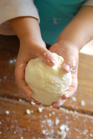 simple edible playdough recipe made by a child holding the ball of playdough