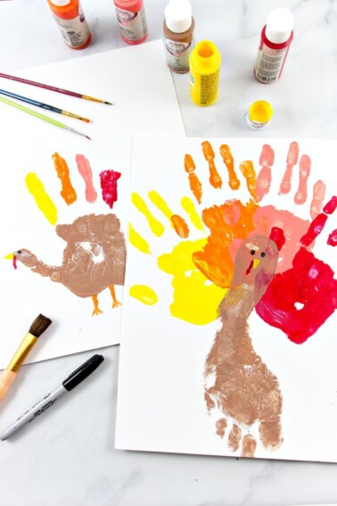Handprint turkey craft for preschool finished on white table - Kids Activities Blog