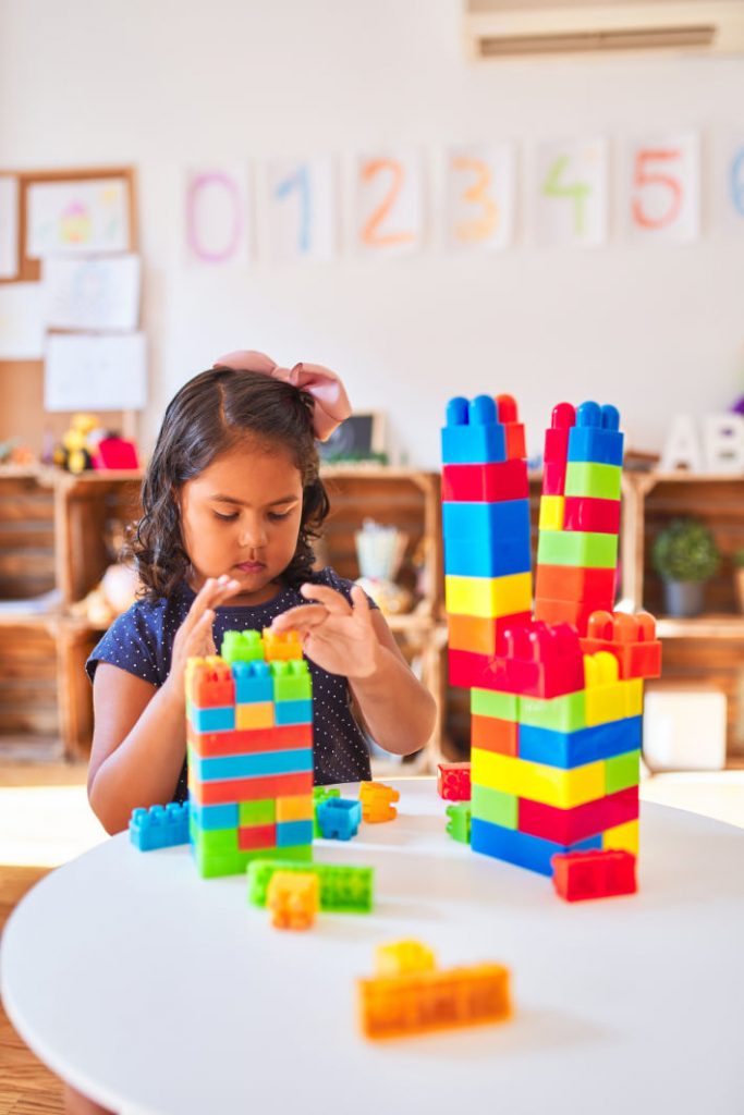 Kindergarten Activities for Learning and Play - Kids Activities Blog - kIndergartner playing with building blocks