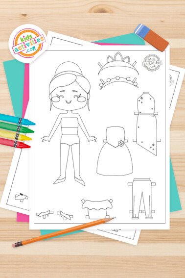 Image shows a dress up paper doll printable next to some crayons.