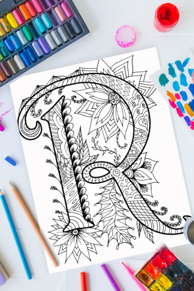 Zentangle alphabet coloring pages - letter r zentangle design on background of paint, colored pencils and art supplies