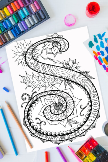 Zentangle alphabet coloring pages - letter s zentangle design on background of paint, colored pencils and art supplies