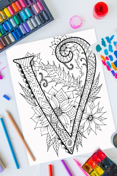 Zentangle alphabet coloring pages - letter v zentangle design on background of paint, colored pencils and art supplies