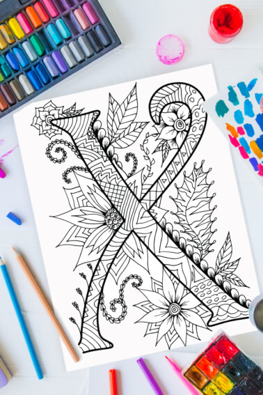 Zentangle alphabet coloring pages - letter x zentangle design on background of paint, colored pencils and art supplies