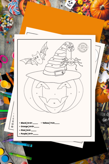 halloween coloring pages addition color by number worksheet on a desk surrounded by Halloween themed art and craft supplies