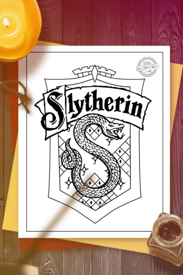 slytherin house crest coloring page on a dest with Harry Potter style glasses, candle, inkpot and quill with the shadow of someone waving a magic wand