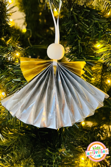 Image shows an angel ornament xmas craft hanging from a tree. - Kids Activities Blog